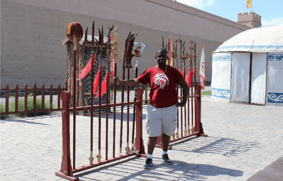 Man standing next to a display of Chinese staffs