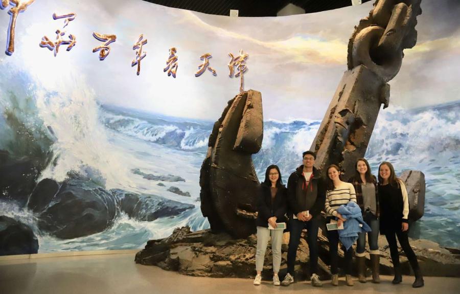 People standing next to a large anchor