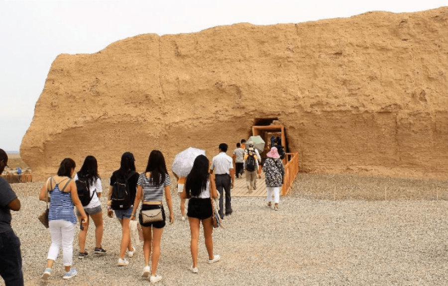 Line of people entering a rock like structure
