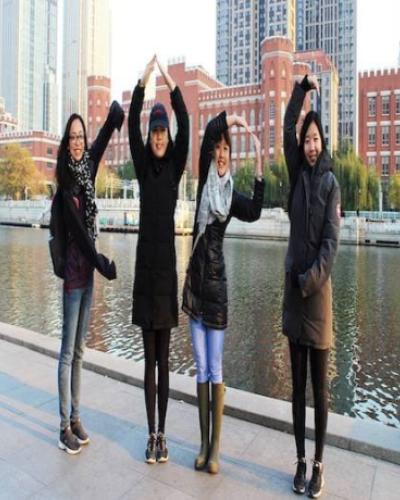 Four women spell &quot;CAPS&quot; with their arms in Tianjin