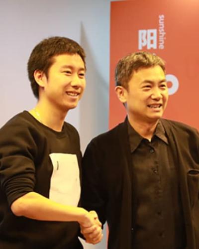 Alumni Randy Wan shakes hands with Mao Daqing